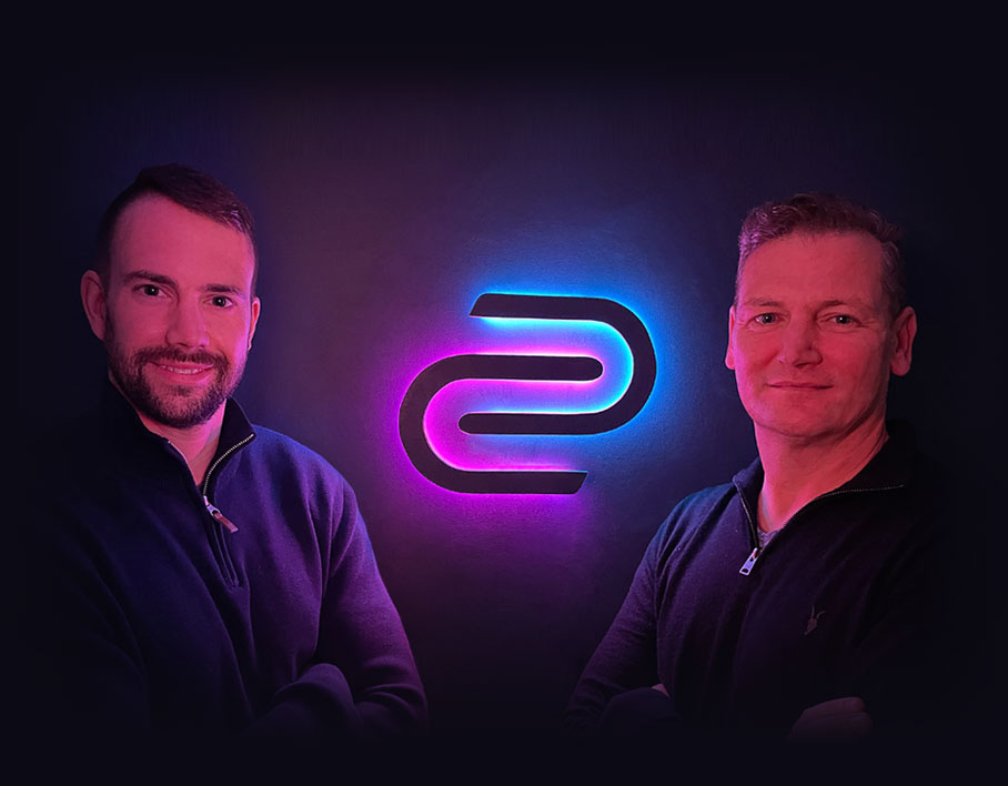 Co-Founders Jack and Mat stood beside the illuminated Downforce Creative logo